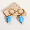 Detailed shot of ocean blue conch shell earrings on natural stone textures - Blue Conch
