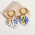 Detailed view of colorful ceramic tropical fish earrings on a textured stone surface - Blue Fish