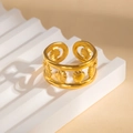 Dettaglio macro di un ampio anello dorato in acciaio inossidabile con motivi a conchiglia - Stile Conchiglia Traforata (#0920)