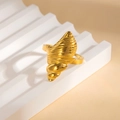 Dettaglio dell'anello a conchiglia dorato con texture a spirale su supporto bianco a onde - Stile Forma Conchiglia (#0924)