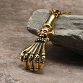 Detailed shot of golden punk ghost claw pendant with red gemstone skull eyes on stone - Gold Color Pendant (No Chain)
