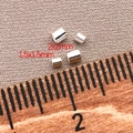Nahaufnahme von 1,5 mm und 2 mm Silber-Abstandshalterperlen mit Lineal zum Maßstab - 1.5x1.5mm Loch 1mm / Dick Versilbert