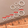 Dettaglio di anellini aperti in argento di varie misure con righello di riferimento - 0.7x4mm / Argento spesso