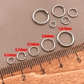 Dettaglio di anellini aperti placcati in oro 18k con righello per misurazione delle dimensioni - 0.7x4mm / Oro Bianco