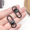 Matte black swivel lobster clasp hardware held by hand for scale and keychain diy - Swim Black Oval Door Buckle (12775)