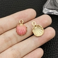 Pendentif en forme de coquillage rose et orange en alliage doré tenu à la main - Huile de Goutte Coquille d'Océan Rose (8605)