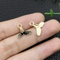 Pendentifs queue de poisson en noir et or présentés à la main pour voir la taille - Queue de Sirène Océan Émail Café (10971)