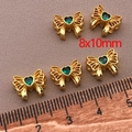 Macro shot of five 8x10mm 18K gold-plated bow beads with green heart zircon stones - Heart-Shaped Bowknot Spacer Bead (T434) / 8x10mm (Hole 2mm, Thickness 5mm) / 1 Piece - Gold With Green Zirconia