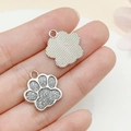 Silver-toned cat paw pendant with gray glitter finish shown on hand for size - White K White Glitter (23332)