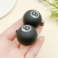 Mini pendentif boule de billard n°8 noir avec anneau de fixation tenu à la main - Boule de Billard Numéro 8 Noir Et Blanc (23148)