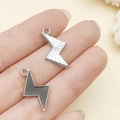 Silver and black lightning bolt charms for DIY jewelry making held in hand for scale - Black Lightning (21899)