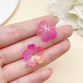 Mano sosteniendo pétalos de flor de cerezo en acrílico degradado de 18mm para DIY - Degradado Rosa Rojo Naranja (22020)