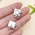 Antique silver graduation cap charms for DIY jewelry making shown in hand for scale - Graduation Cap (10895)