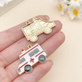 Cartoon ambulance bedeltje in wit emaille met rood kruis en goudkleurige variant - Witte Ambulance (23069)