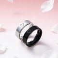 Close-up of crown engraved couple rings in black and silver on romantic petal background - Heart Pattern (Couple Ring Style 6)
