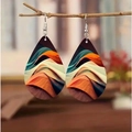 Detail of bohemian teardrop earrings featuring orange and blue waves on a wooden branch - Style 4