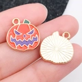 Colgante de calabaza de Halloween con esmalte naranja y acabado dorado mostrado a mano - Calabaza Malvada de Halloween Esmaltada Naranja (19538)