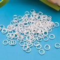 Pile of silver-plated jump rings for jewelry making on bright blue background - 4x0.7mm (Approx. 100 Pcs/Pack) / Bright Silver