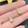 Golden sea-themed alloy charms for DIY jewelry held in hand to show realistic size - KC Gold Marine Shell Style (18317)