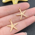 Detailed pair of golden starfish alloy charms for DIY jewelry making on fingertip - KC Gold Marine Starfish Style (18318)