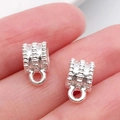 Par de conectores de plata para creación de joyas DIY mostrados en la punta del dedo - Enganche Triple Plata Brillante (20683)