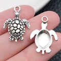 Colgante de tortuga de plata para joyería DIY, mostrado en la mano para escala real - Tortuga Marina Plata Antigua (11264)