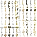 Set de dijes musicales con guitarras y notas en cinco acabados metálicos - Juego de 100 Piezas de Instrumentos Musicales (SN898)