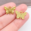 Colgante de mariposa de aleación dorada para joyería DIY mostrado en la yema del dedo - Estilo Mariposa Oro Antiguo (20174) / 16x12mm
