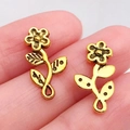 Vintage gouden zonnebloem hanger met antieke afwerking vastgehouden door vingertoppen - Antique Gold Long Flower (19x10mm)