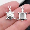 Vista detallada frontal y trasera de dijes de tortuga plateados para joyería artesanal - Tortuga Océano Plata Brillante (20690)