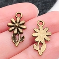 Vintage bronzen daisy bloem hanger getoond op kleine schaal op de vingertoppen - Antique Bronze Flower (17x10mm)
