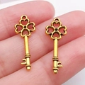 Set de dos colgantes de llave de trébol dorados para hacer joyas vintage de bricolaje - Llave de Oro Antiguo (11369)
