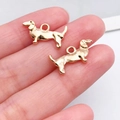 Goldene Dackel-Anhänger für DIY-Schmuck in der Hand zur Größenansicht präsentiert - KC-Gold Langgestreckter Hund (20524)