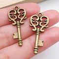 Colgante de llave vintage de bronce con diseño de volutas para joyería artesanal - Llave Bronce Antiguo (20986)