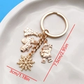 Golden Christmas keychain with charms including Santa, tree, and snowflake pendants - Santa Gloves Snowflake Tree Style (ER824)