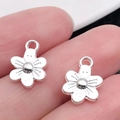 Handbeeld van een gepolijste zilveren bloemenhanger die de kleine maat en textuur laat zien - Bright Silver Flower (12x9mm)