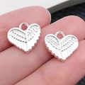 Zilveren hartvormige hanger met vederstructuur voor DIY-sieraden op een vingertop - Glanzend Zilveren Hart Vleugels (19962)