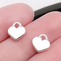Gepolijste zilveren hartvormige hanger op vinger die de maat toont voor DIY-sieraden - Glanzend Zilveren Hart (19969)