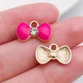 Pink enamel bow pendant with clear zircon inlay and golden metallic texture for DIY jewelry - Rhinestone Bow Style / Rose Red