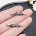 Retro silver fish bone alloy pendants for DIY jewelry making shown in hand for size - Antique Silver Fish Bone Style (21411)