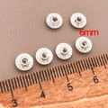 Detail view of six 6mm silver saucer beads with concentric relief patterns for DIY jewelry - 6mm / Flat UFO Spacer Bead (T97) / Silver