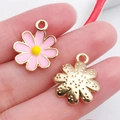 Pink enamel daisy and gold textured metal flower pendants on fingertips for DIY jewelry - Pink Enamel Daisy Flower Style