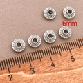 Macro shot of 6mm silver saucer spacer beads with detailed relief pattern for jewelry DIY - Flat UFO Spacer Bead (T561)