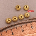 Detailed macro view of 5mm 18K gold-plated spacer beads with intricate spiral floral patterns - 5mm / Thick UFO Spacer Bead (T100) / 18K Gold