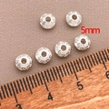 Close-up of 5mm silver saucer beads with vintage patterns for DIY jewelry making - Thick UFO Spacer Bead (T99)