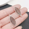 Silver alloy hollow leaf pendants for DIY jewelry making held in hand for scale - Antique Silver Leaf Style (11271)