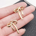 Ciondoli a fiocco dorati in lega con piccoli strass per la creazione di gioielli fai da te - Fiocco con Strass (26x20mm)