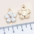 White enamel sakura flower pendant in golden alloy with reverse side texture view - 14x16mm / White