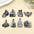Detailed flat lay of eight pink and black Gothic enamel Halloween charms for jewelry making - Gramophone Clapperboard Typewriter Butterfly Record Potion Jar TV Set (SN1091)