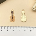 Golden guitar enamel charms with light orange finish and scale ruler for size reference - Yellow Guitar